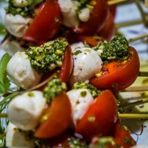 Cherry tomatoes with mozzarella pearls and pesto dressing